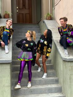 three people in matching outfits sitting on the steps and talking to each other while looking up