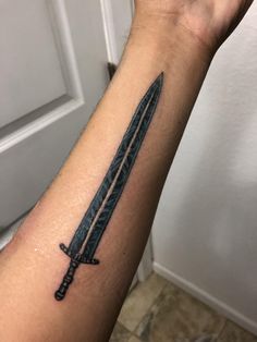 a person with a tattoo on their arm holding a knife