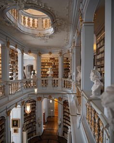 the interior of a large library with many bookshelves and sculptures on each floor