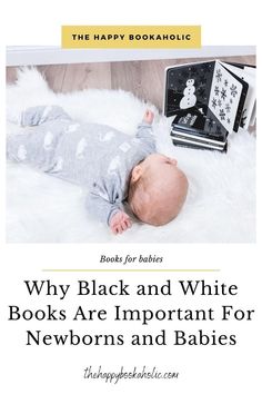 a baby laying on top of a white rug next to a black and white book