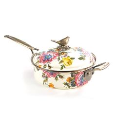 a white casserole with flowers on it and a bird sitting on the lid