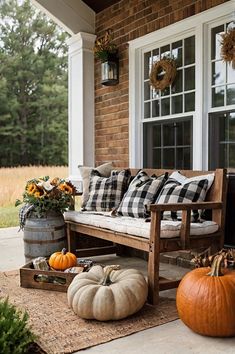 a porch decorated for fall with pumpkins and other decorations