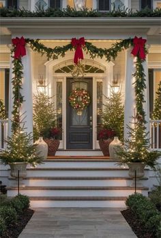 the front porch decorated for christmas with wreaths and garland on it's pillars