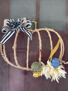 a pumpkin shaped wreath with flowers on it