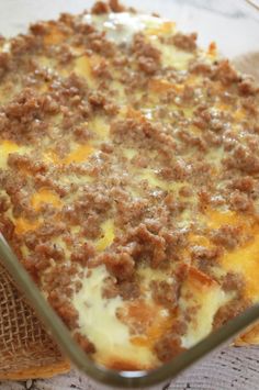 a casserole dish with meat and cheese in it sitting on a cloth napkin