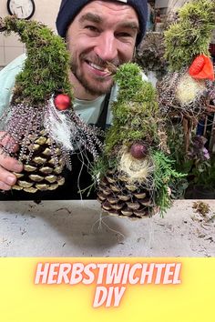 a man holding two pine cones with plants growing out of them in front of him