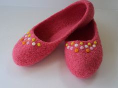 a pair of pink slippers sitting on top of a white table