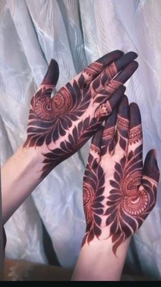 two hands with henna designs on them