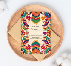 a colorful wedding card on top of a wooden plate