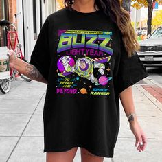 a woman wearing a buzz lightyear shirt on the street