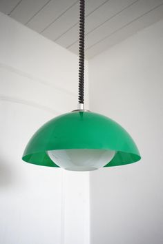 a green light hanging from a ceiling in a room