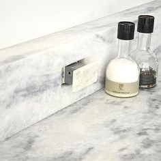 a marble counter top with two bottles and a soap dispenser