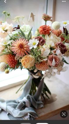 a vase filled with lots of flowers on top of a table