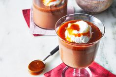 two glasses filled with chocolate pudding and whipped cream