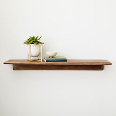 a wooden shelf with a potted plant on it