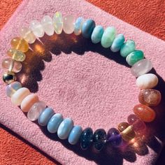 Our Rainbow 'Love' bracelet features an array of gemstones found in the Rainbow Love Necklace. This includes a selection from Peru and Pink opal, Rose Quartz, Moonstone, Chrysoprase, Strawberry Quartz, Peach Moonstone, Fluorite, Prehnite, Amethyst, Larimar, Sky blue Apatite and Ruby. DETAILS Gemstone : mixed Length : 6.5" Beads : 7-8mm Thread : Elasticated thread The bracelet comes packaged in a plush Bon Bon velvet bag Vibrational Energy, Love Bracelet, Peach Moonstone, Blue Apatite, Strawberry Quartz, Tutti Frutti, Bon Bon, Velvet Bag, Pink Opal