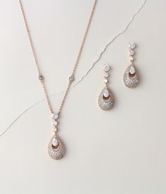 "Pretty rose gold pendant necklace so sparkly with Swarovski Pure brilliance stones ! This is available in a set or by itself. Please choose from drop down menu. Necklace measures 17 inches and extends to 19 inches Pendant portion measures 1.75\" x 5/8\" Earrings measure 1.75\" x 5/8\" Matching bracelet: https://www.etsy.com/listing/674474135/rose-gold-bridal-bracelet-teardrop?ref=shop_home_active_1&pro=1&frs=1 Back to my shop: https://www.etsy.com/shop/TheExquisiteBride?ref=l2-shopheade Elegant Rose Gold Necklace With Matching Earrings, Rose Gold Cubic Zirconia Drop Jewelry, Rose Gold Dangle Jewelry With Sparkling Stones, Rose Gold Sparkling Drop Earrings, Rose Gold Dangle Necklaces With Matching Earrings, Rose Gold Dangle Jewelry Sets With Matching Earrings, Gold Drop Earrings Wedding, Rose Gold Statement Necklace, Rhinestone Wedding Jewelry