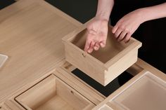 a person reaching into a wooden box on top of a table