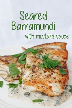 grilled barramundi with mustard sauce on a white plate, garnished with parsley