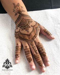 a woman's hand with henna tattoos on it