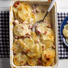 a casserole dish with potatoes and ham in it on a checkered table cloth