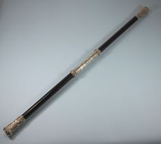 an ornate black and gold cane on a white surface with silver trim around the handle