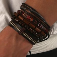 a close up of a person's arm wearing bracelets with beads and leather