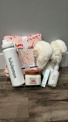 a teddy bear sitting on top of a wooden floor next to bottles and other items