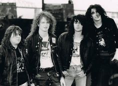 an old black and white photo of four young men with long hair standing next to each other