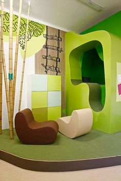 a room with green walls and furniture in the center, including a chair that is shaped like a house