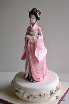 a cake decorated with a geisha doll on top