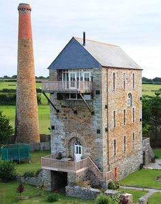 an old brick building with a tall chimney in the middle of it's yard