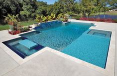 an empty swimming pool in the middle of a yard with trees and shrubs around it