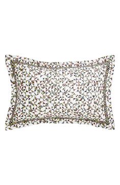 a white pillow with multicolored dots on the front and back of it's cover