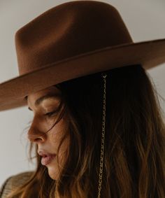 Think of the Raine as three hats in one. The removable paperclip brass chain features three pearls, + our first ever chain chinstrap can stay clipped into the hat or not, it’s totally up to you. Strip the Raine down to its basic form, the wide brim fedora, to showcase a hand-sewn grosgrain band with the gold Gigi Pip bar. This is a hat for a woman who loves options. Gigi Pip, Wide Brim Fedora, Halo Style, Wearing A Hat, Find Color, Felt Hat, Fedora Hat, Brass Chain, Wide Brimmed