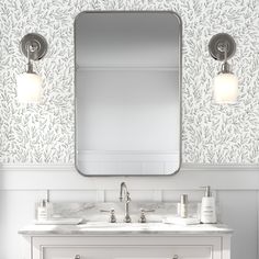 a bathroom vanity with two sinks and a large mirror above it, in front of a wallpapered background