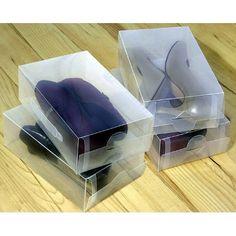 three clear boxes with purple mouses in them on a wooden table, one is empty