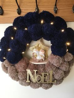 a wreath with lights around it and a nativity figurine