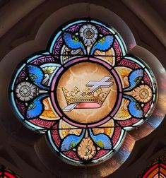 an ornate stained glass window with flowers and birds on it's center piece in a church