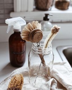 a glass jar filled with toothbrushes sitting on top of a counter next to a sink