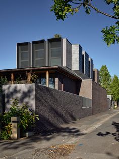 the house is made out of concrete and has black shutters