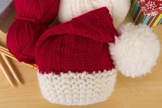 knitted hats and knitting needles on a table