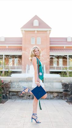 a woman standing in front of a building holding a blue purse