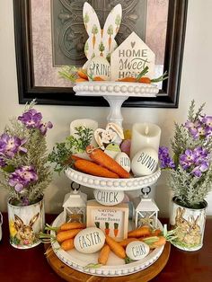 there is a tiered tray with carrots and other decorations on it, along with some candles