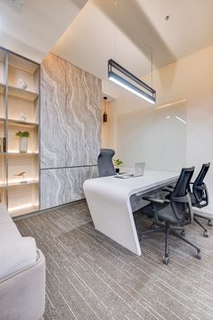 an office with a white table and black chairs