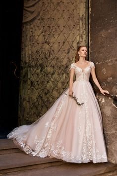 a woman in a wedding dress leaning against a wall with her hand on the door