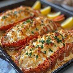 cooked lobsters with lemon wedges and parsley on a baking sheet, ready to be served