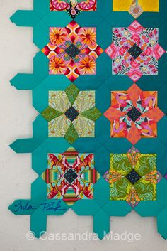 a quilted wall hanging with many different designs on it's sides and the bottom half