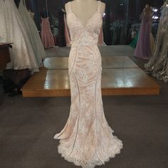 a wedding dress on display at a bridal shop in front of mannequins