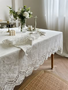 the table is covered with white lace and flowers